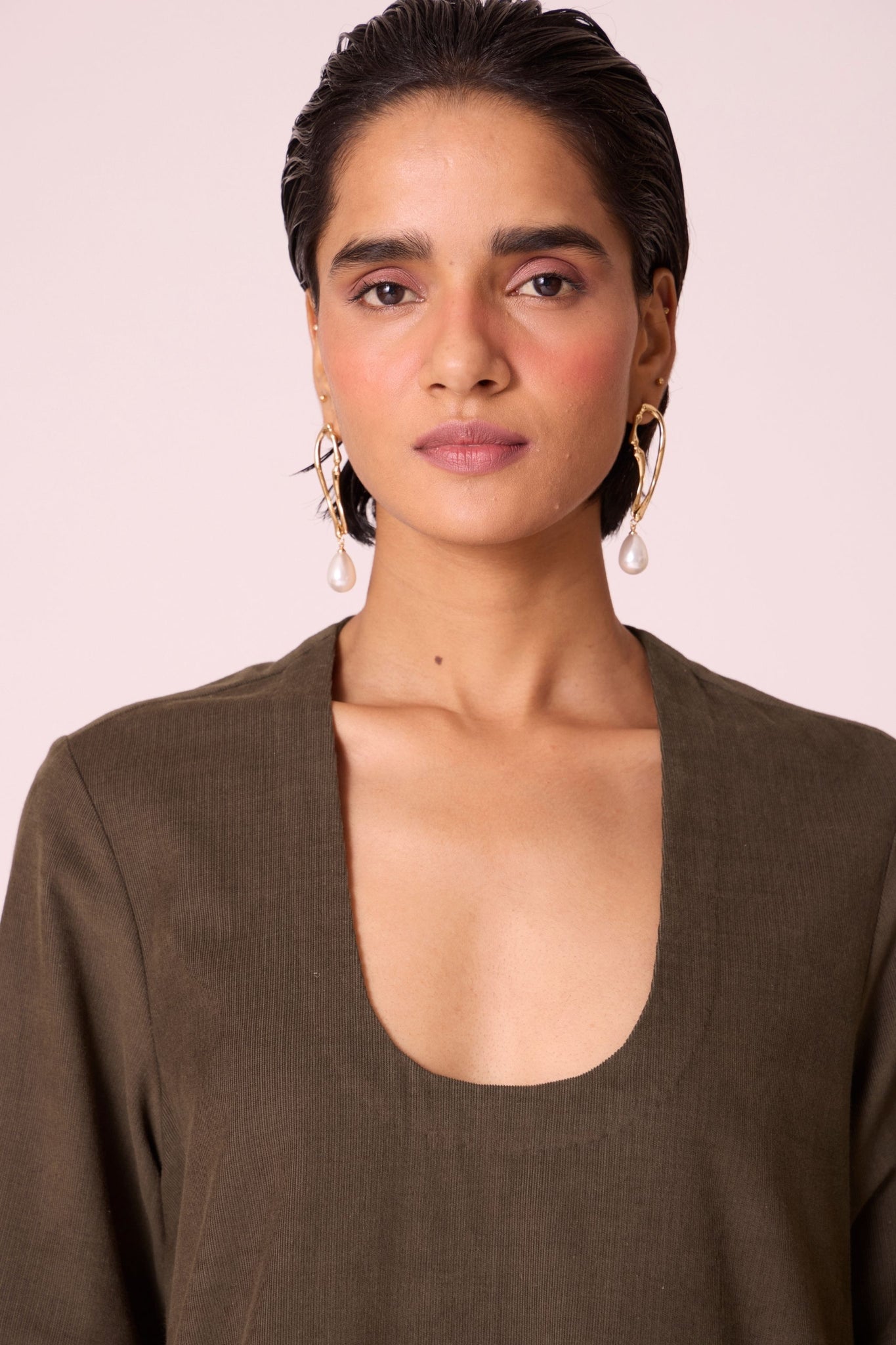 Olive needlecord A-line dress with drop shoulder, hand-embroidered cuff, deep scoop neckline, and in-seam pockets.