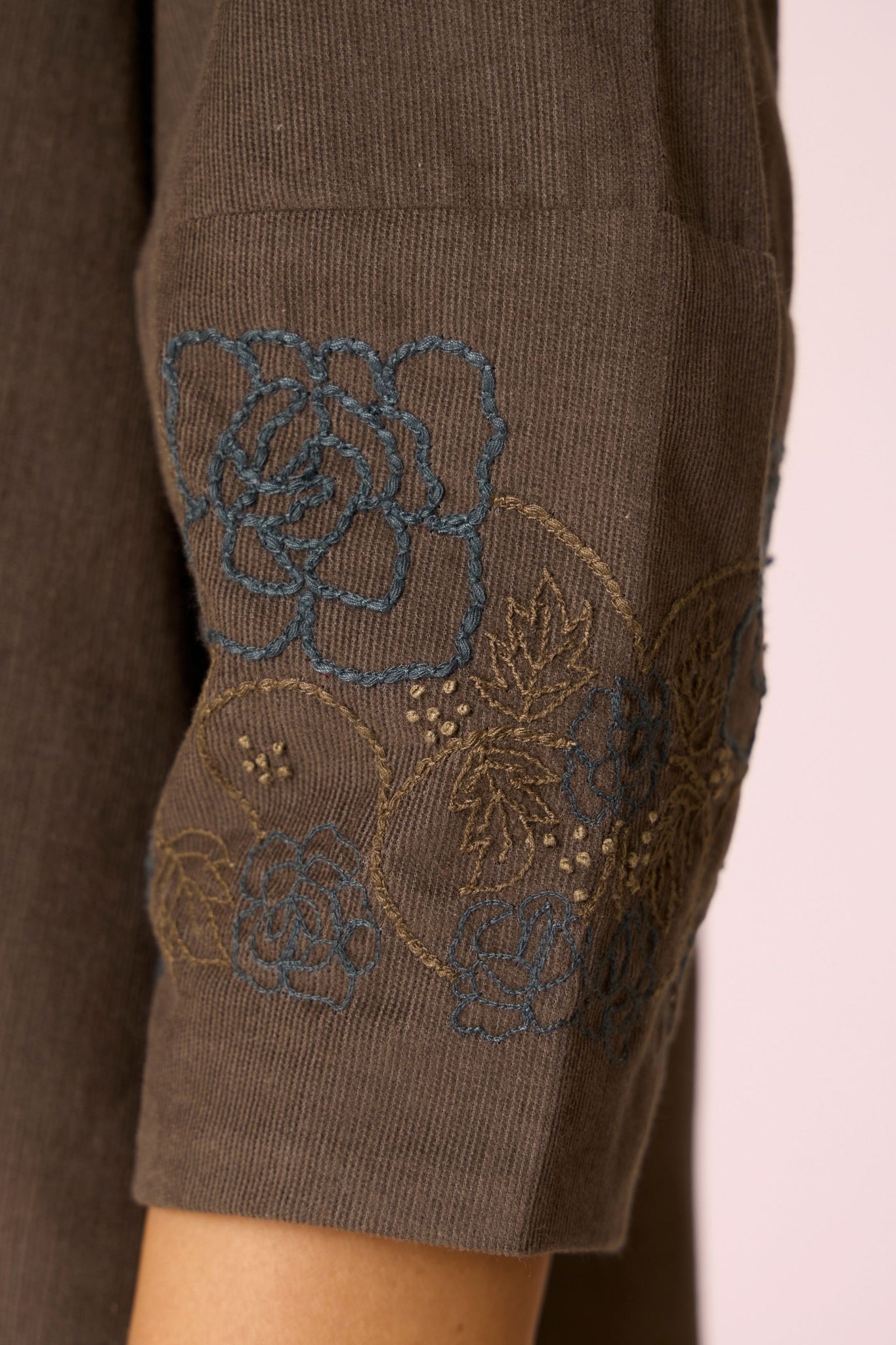 Olive needlecord A-line dress with drop shoulder, hand-embroidered cuff, deep scoop neckline, and in-seam pockets.