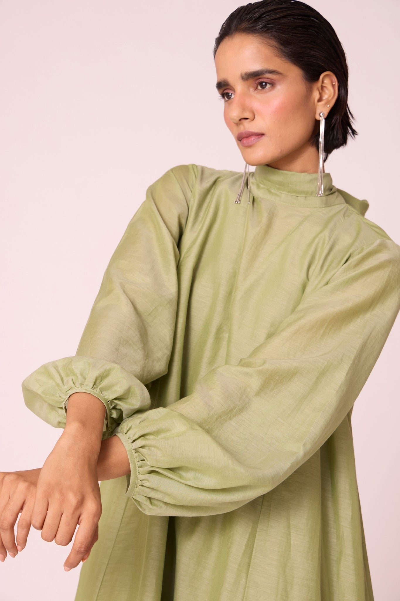 Green silk-cotton panelled short dress with halter neck, back tie, bishop sleeves, and lined body.
