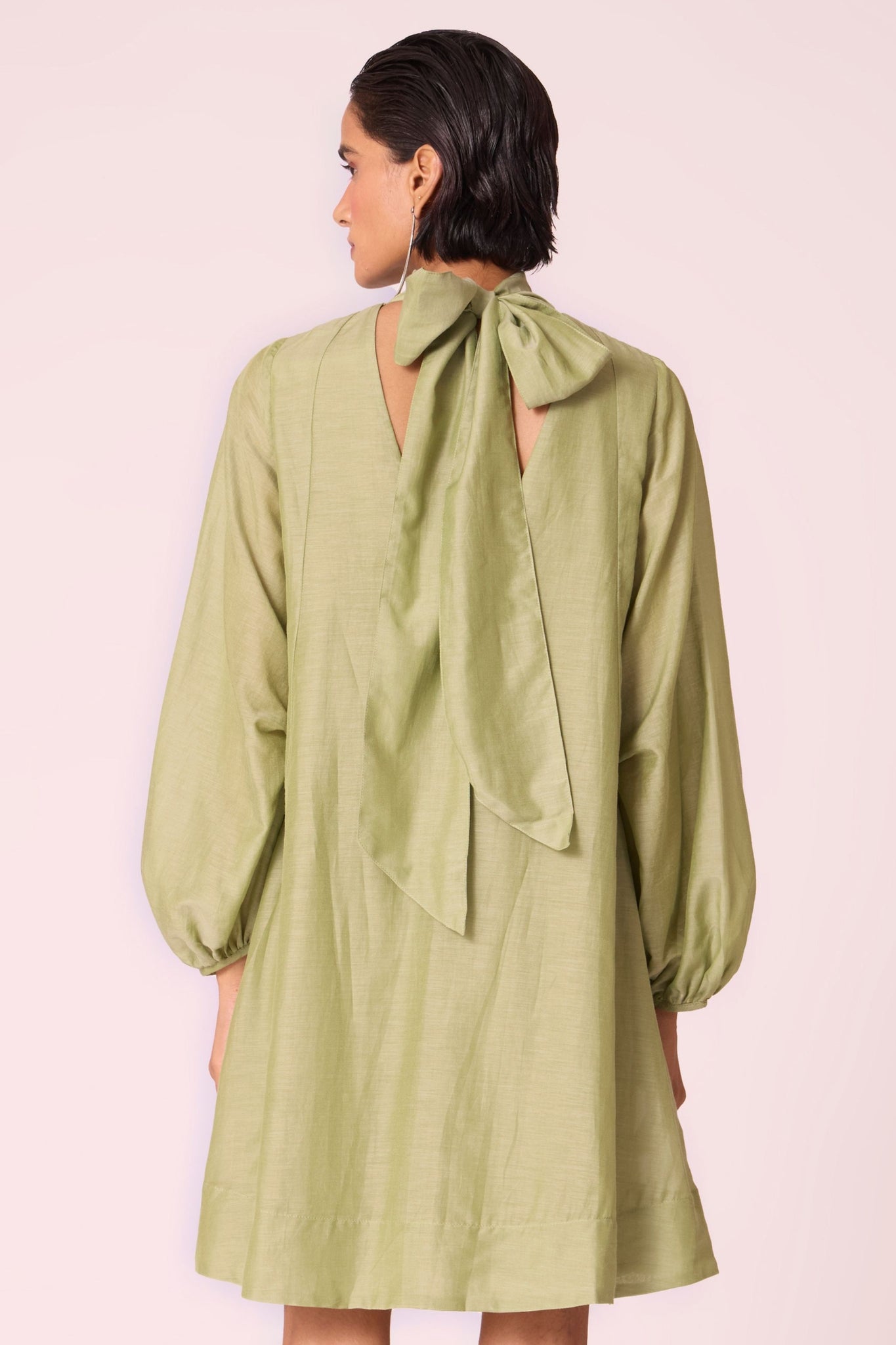 Green silk-cotton panelled short dress with halter neck, back tie, bishop sleeves, and lined body.