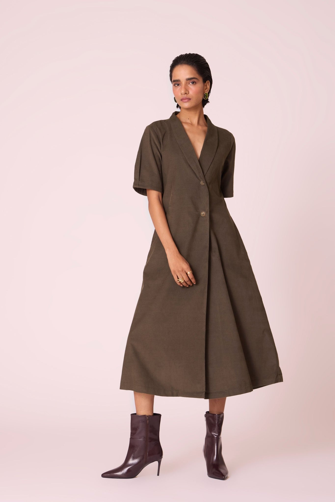 Olive needlecord structured wrap dress with double button fastening, shawl collar, sleeve box pleats, and in-seam pockets.