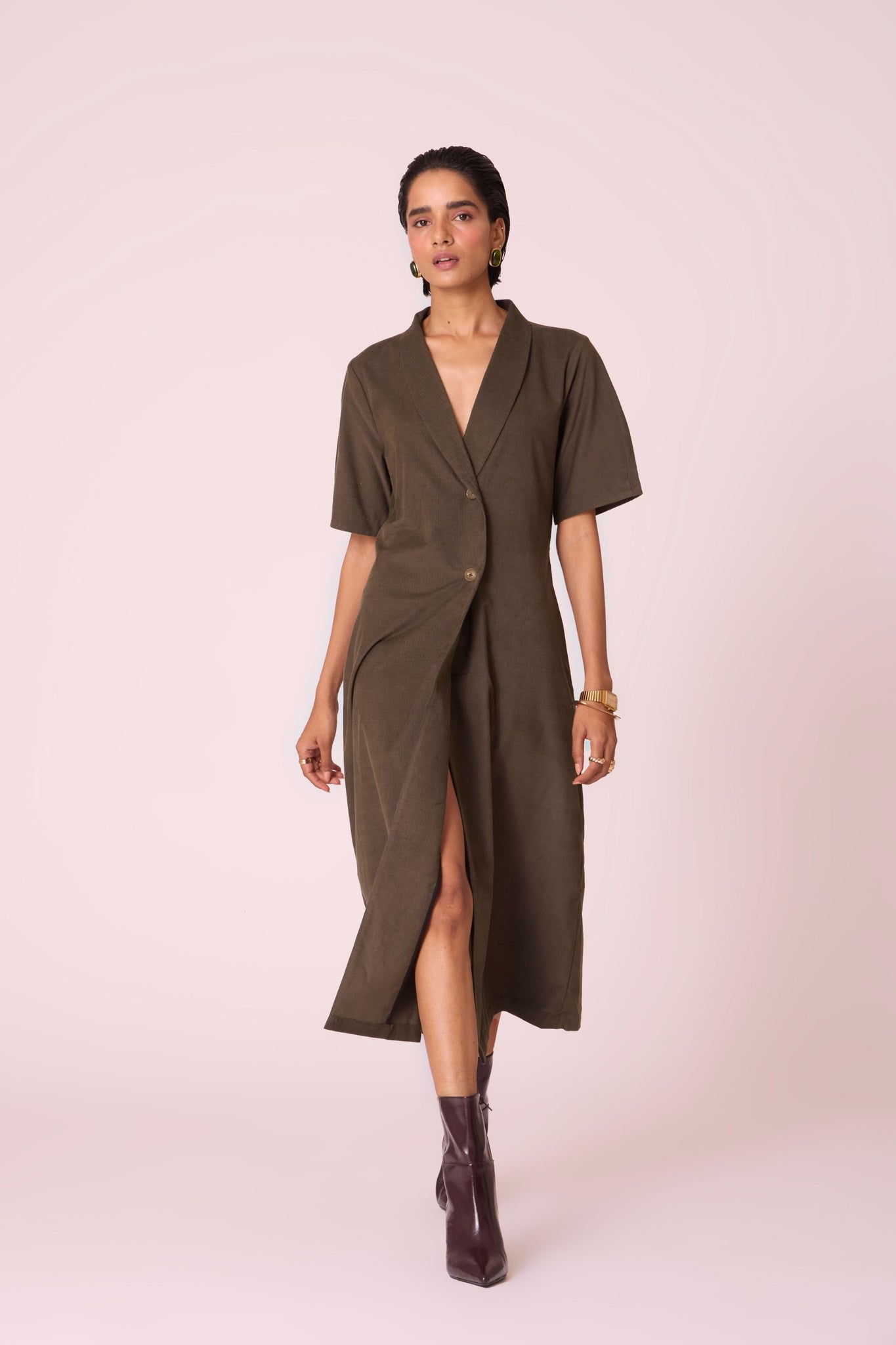Olive needlecord structured wrap dress with double button fastening, shawl collar, sleeve box pleats, and in-seam pockets.