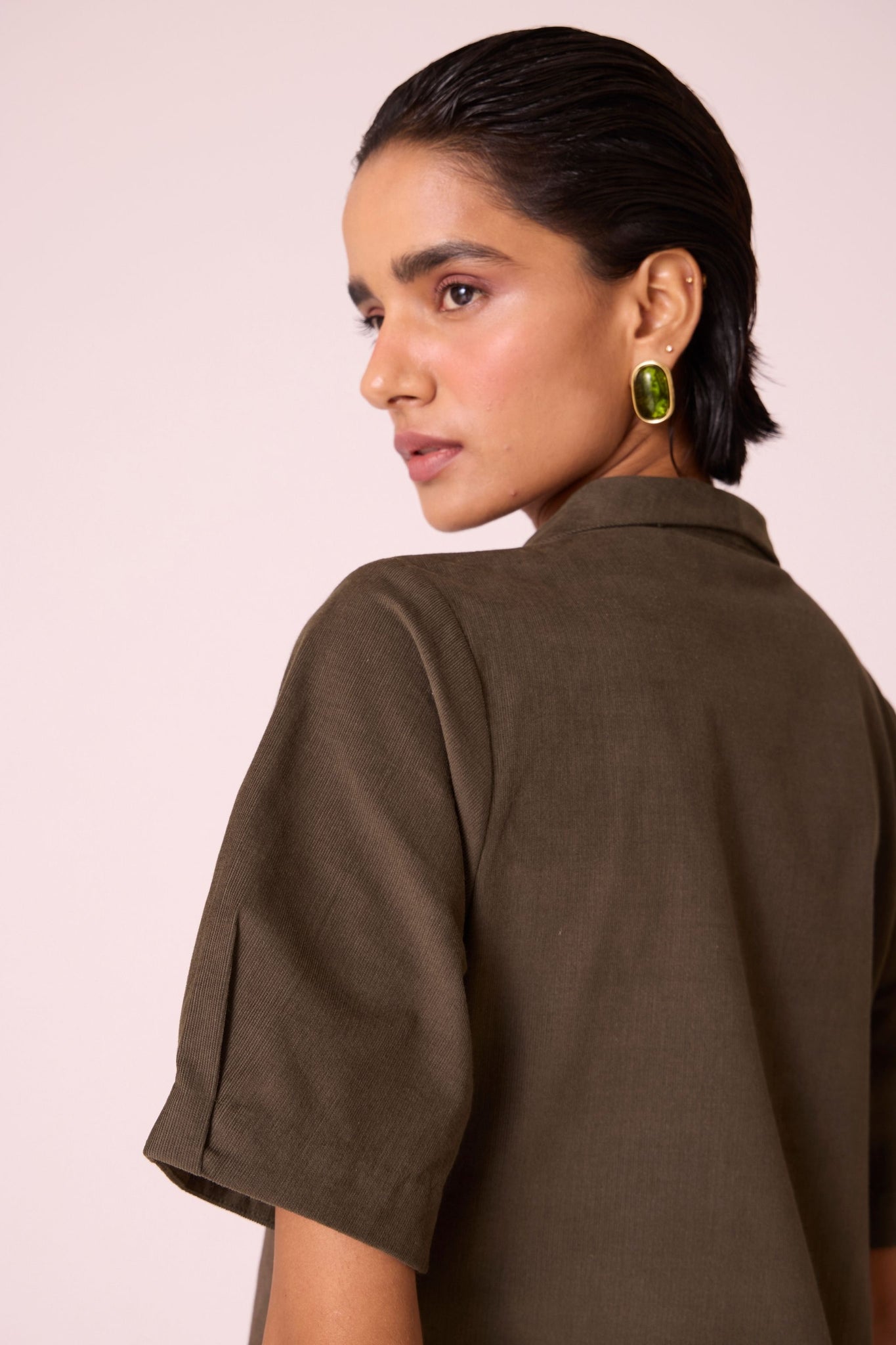 Olive needlecord structured wrap dress with double button fastening, shawl collar, sleeve box pleats, and in-seam pockets.