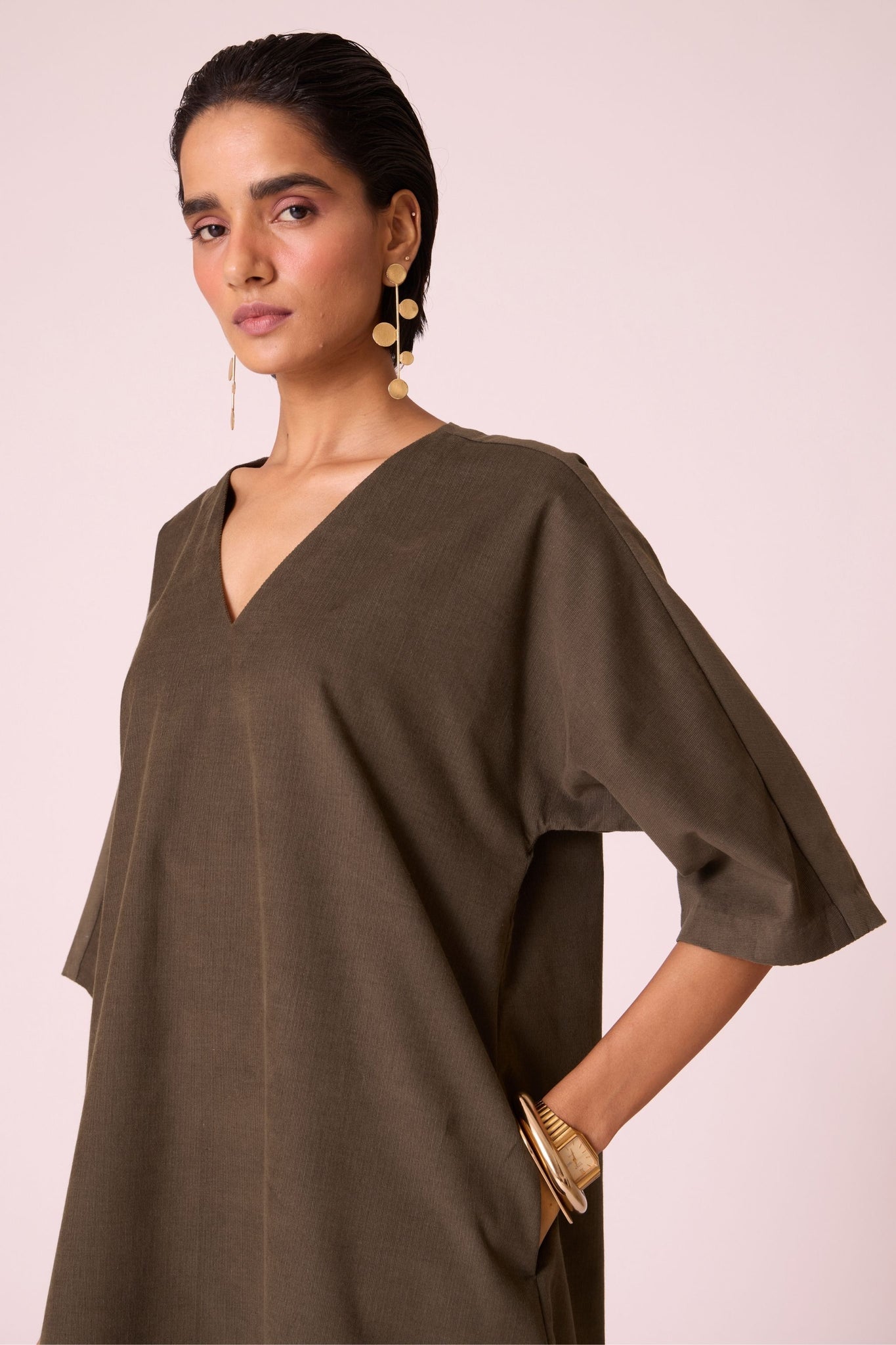Olive needlecord shift dress with V-neckline, kimono-inspired sleeves, and in-seam pockets.