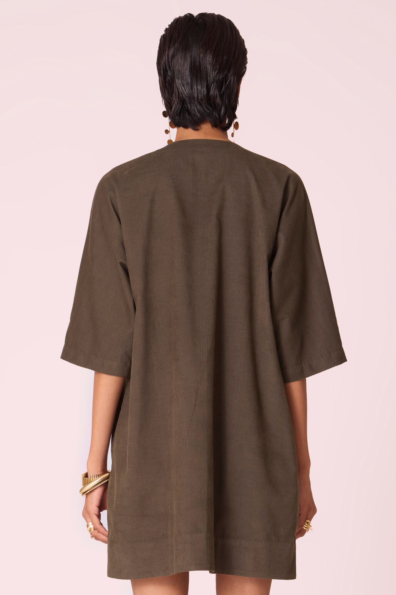 Olive needlecord shift dress with V-neckline, kimono-inspired sleeves, and in-seam pockets.