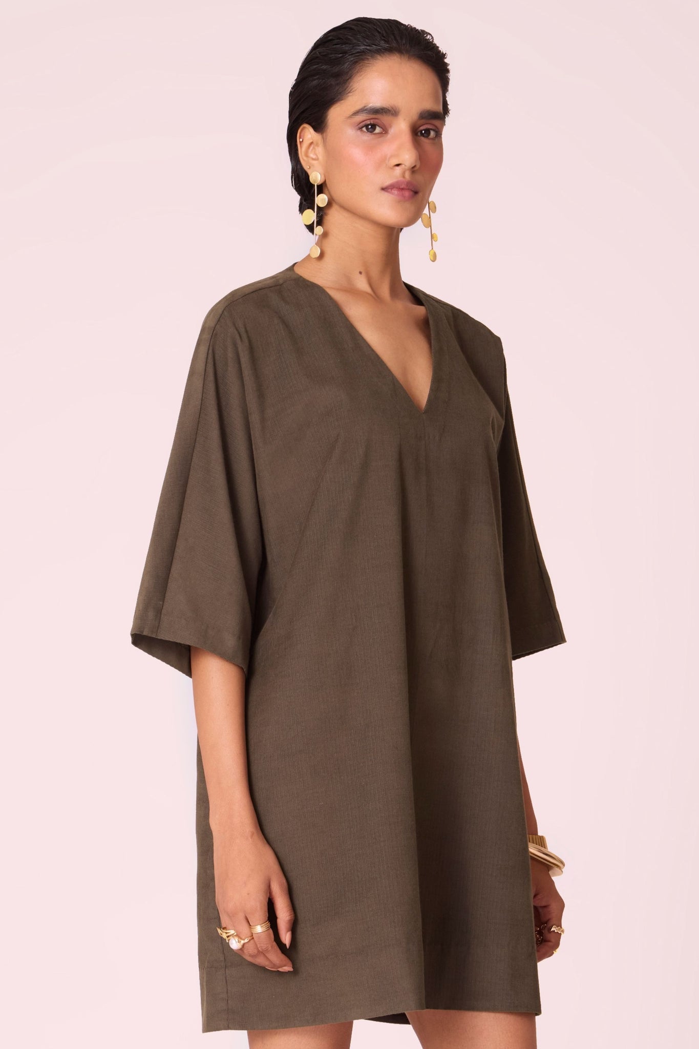 Olive needlecord shift dress with V-neckline, kimono-inspired sleeves, and in-seam pockets.