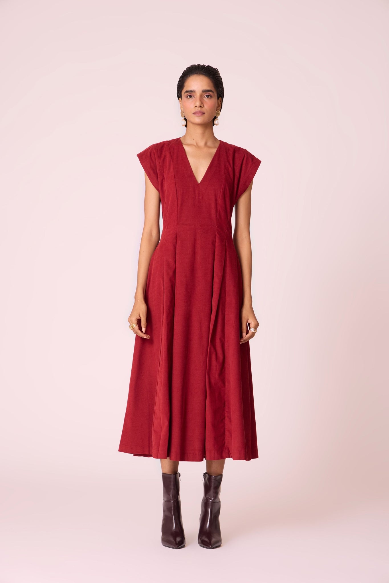 Rust needlecord panelled dress with box pleats, structured drop shoulder, V-neckline, side zip, and in-seam pockets.