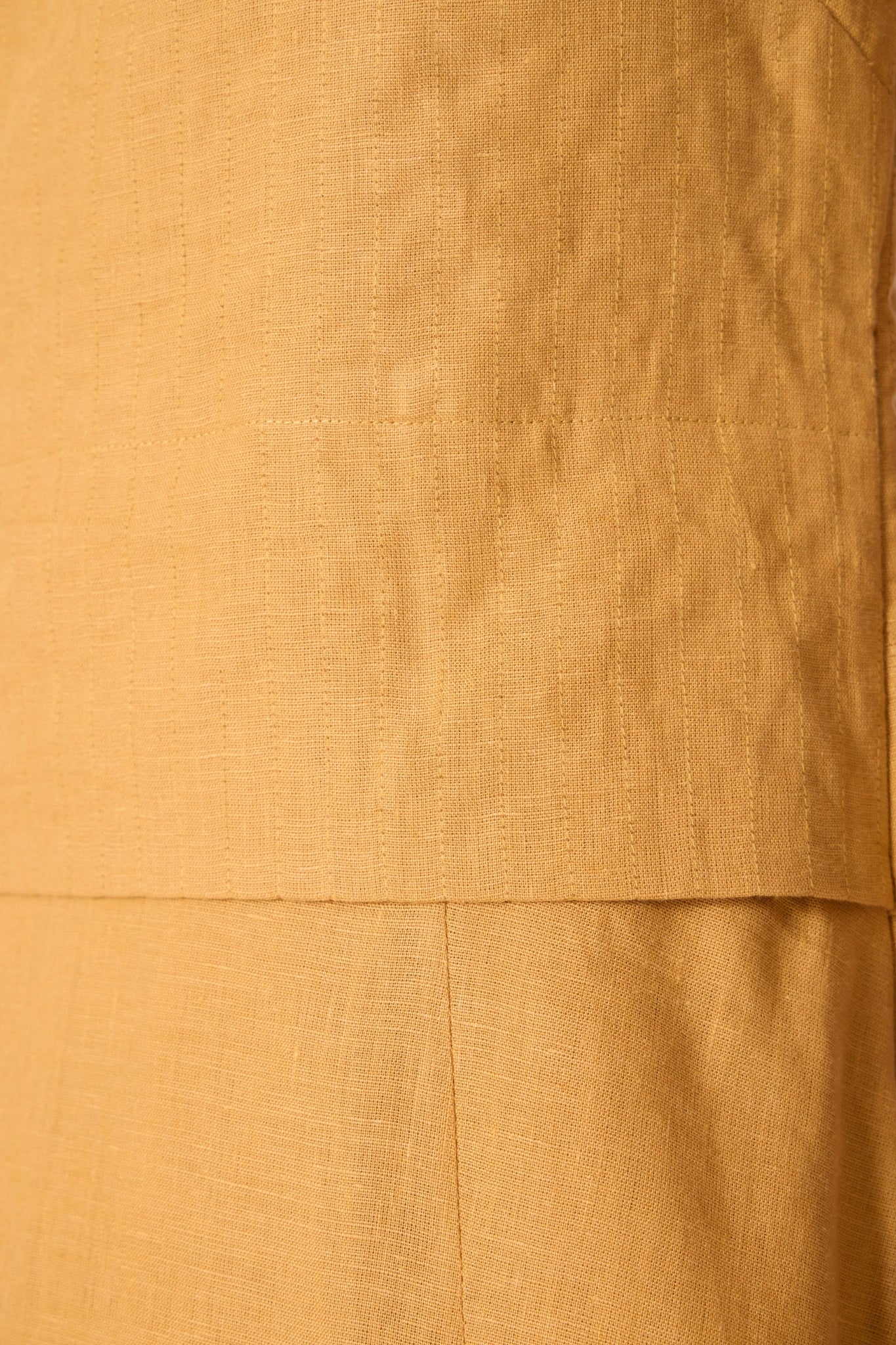 Yellow linen panelled dress with quilted low-waist yoke, paneled hemline, full lining, and in-seam pockets.