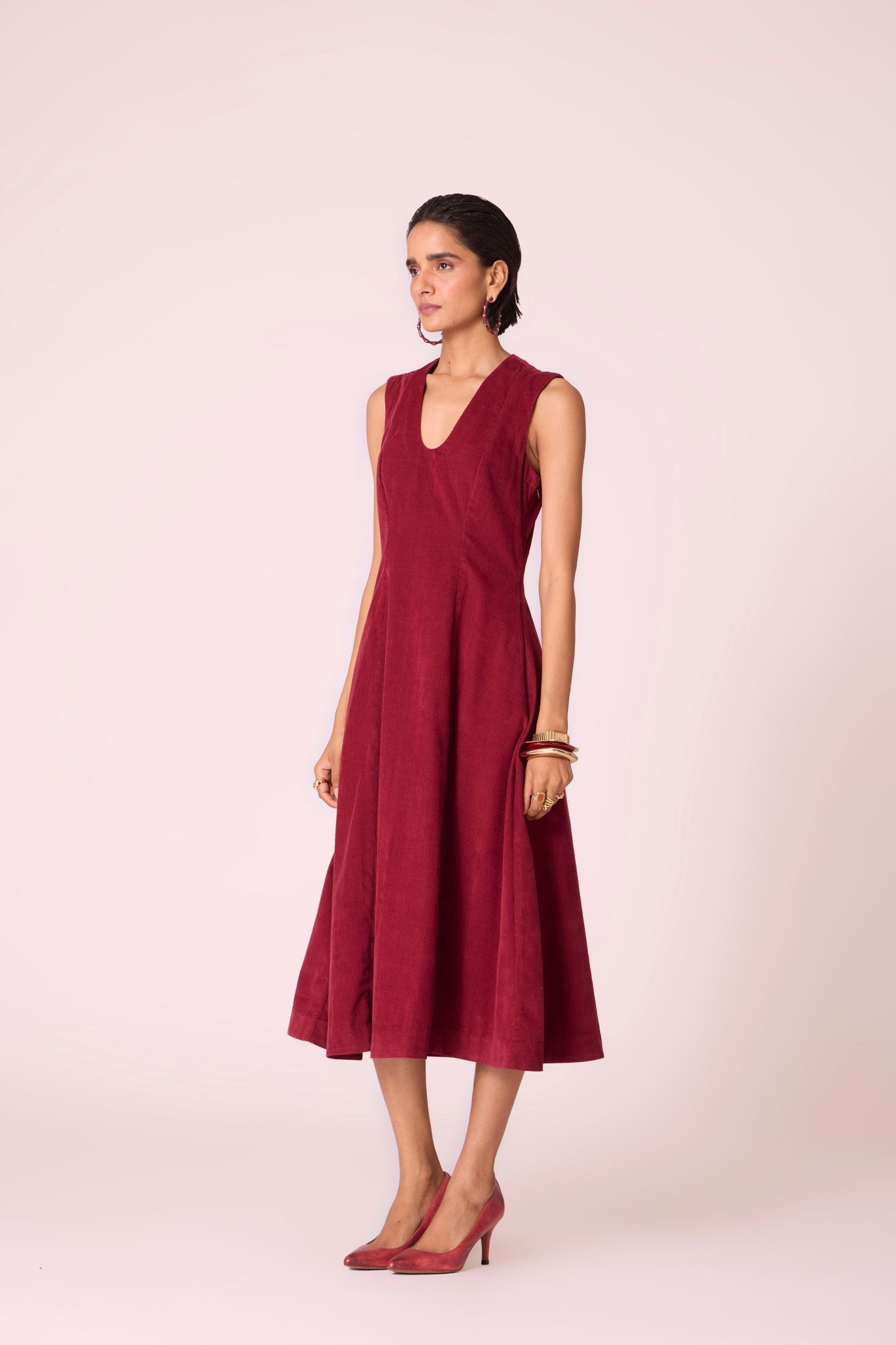 Cherry needlecord fit-and-flare midi dress with soft V-neckline, panel detailing, side zip, and in-seam pockets.
