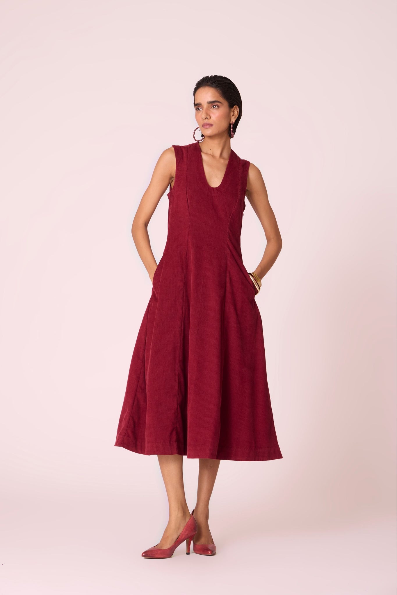 Cherry needlecord fit-and-flare midi dress with soft V-neckline, panel detailing, side zip, and in-seam pockets.
