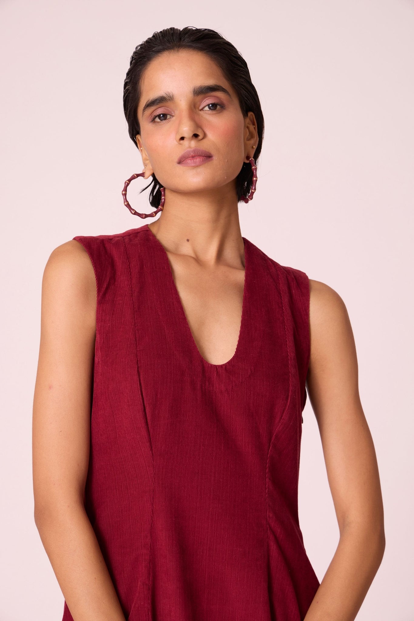 Cherry needlecord fit-and-flare midi dress with soft V-neckline, panel detailing, side zip, and in-seam pockets.
