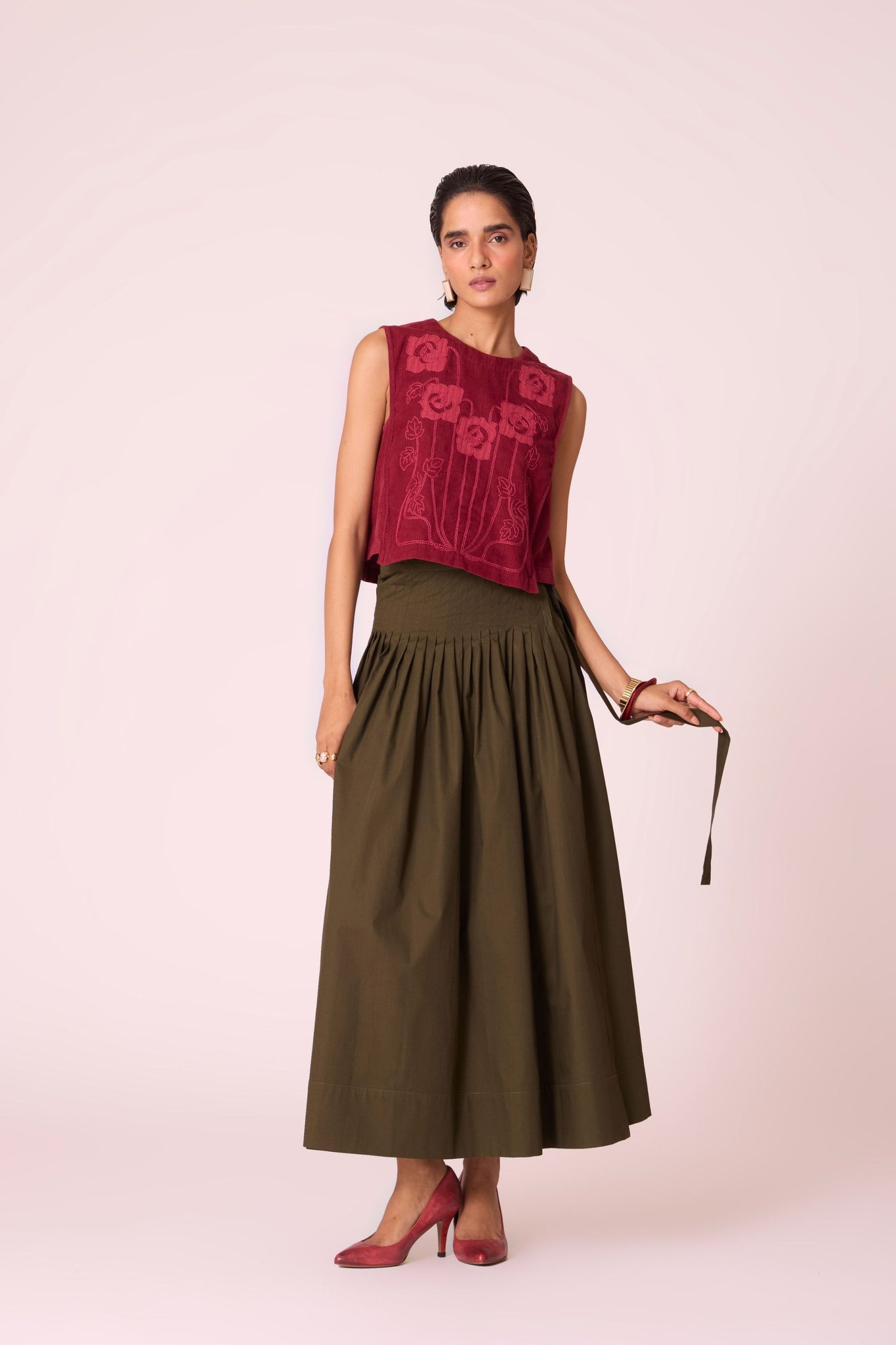 Green cotton poplin pleated midi wrap skirt with adjustable wrap fastening.