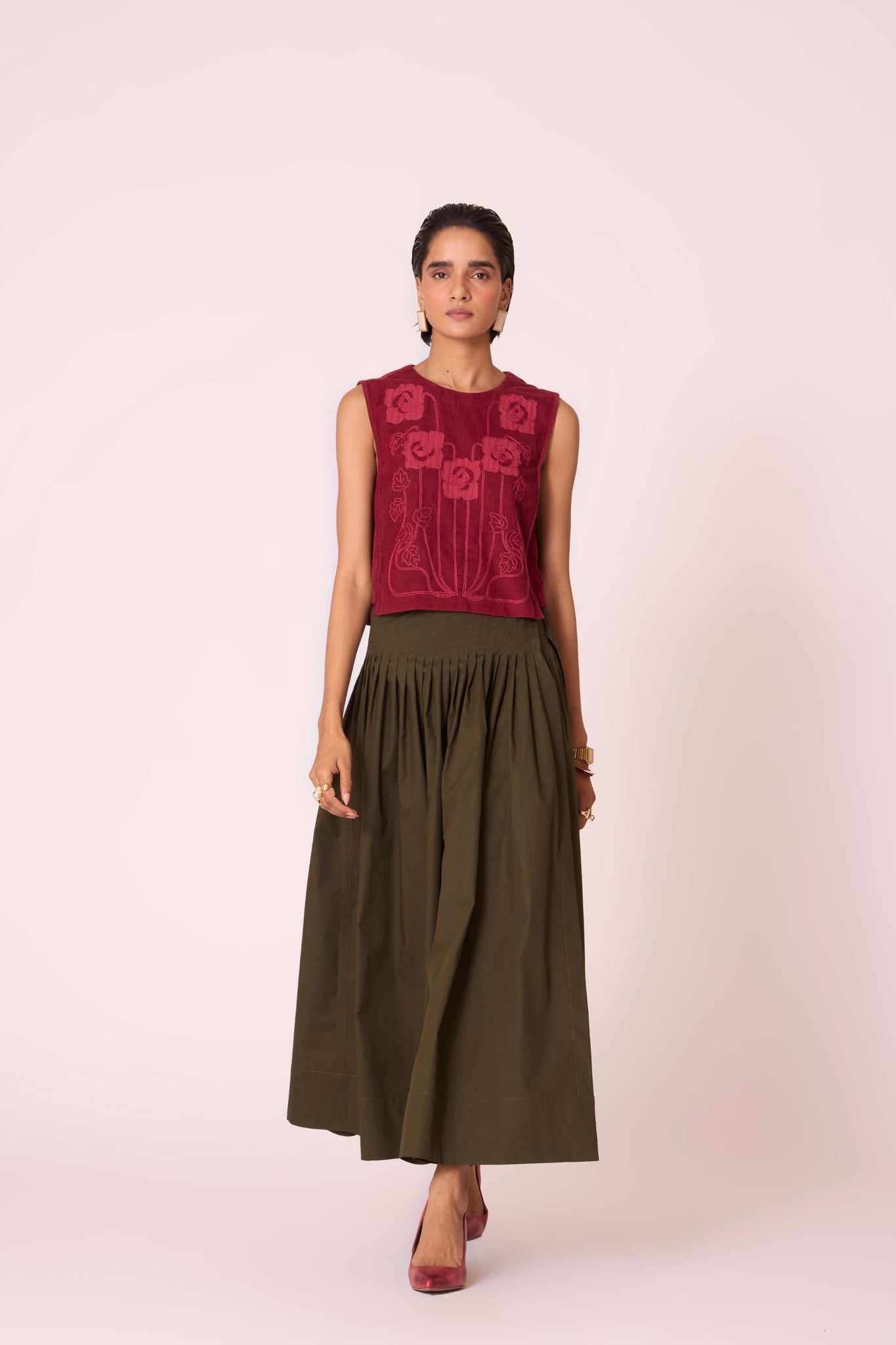 Green cotton poplin pleated midi wrap skirt with adjustable wrap fastening.