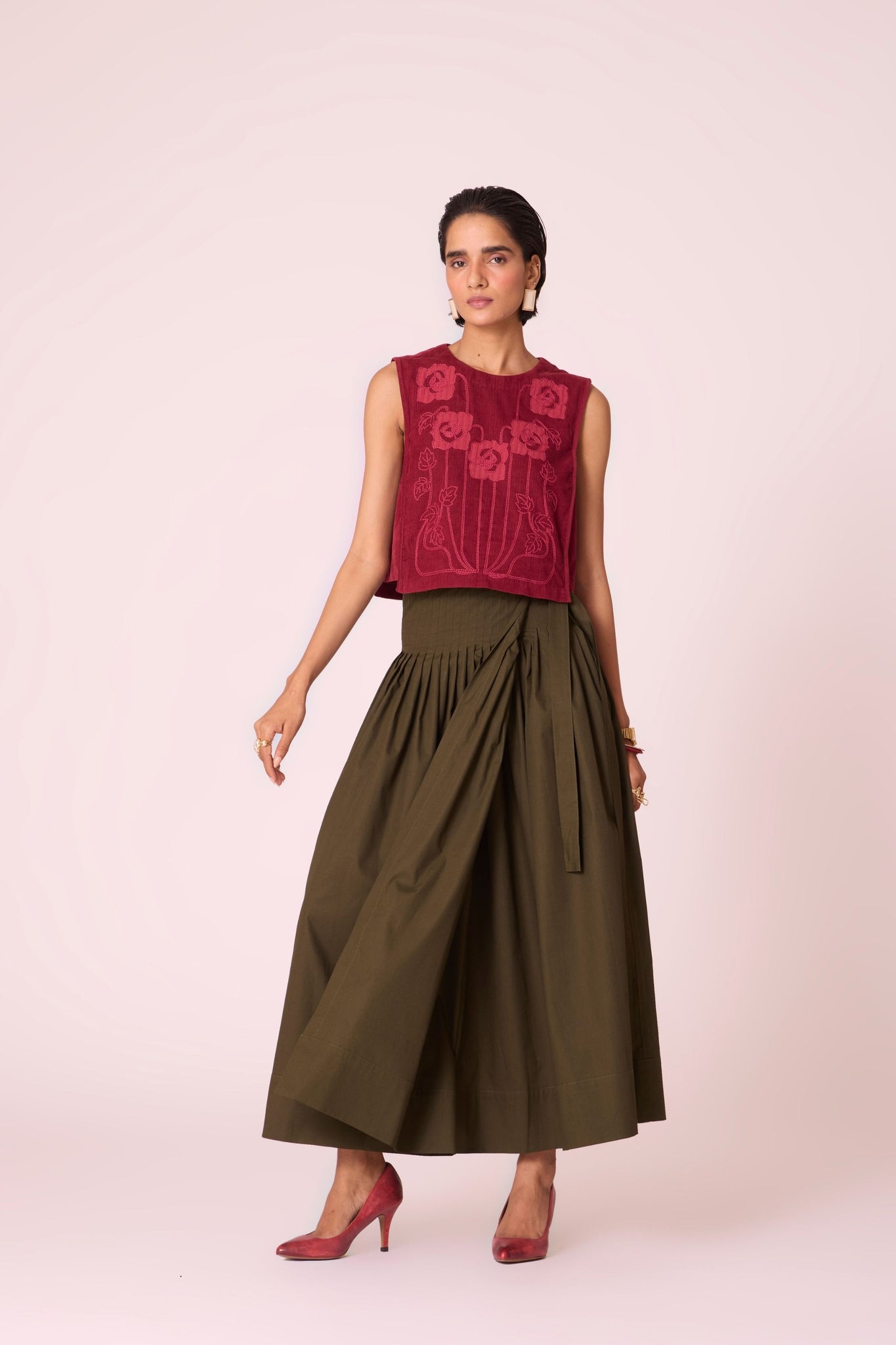 Green cotton poplin pleated midi wrap skirt with adjustable wrap fastening.