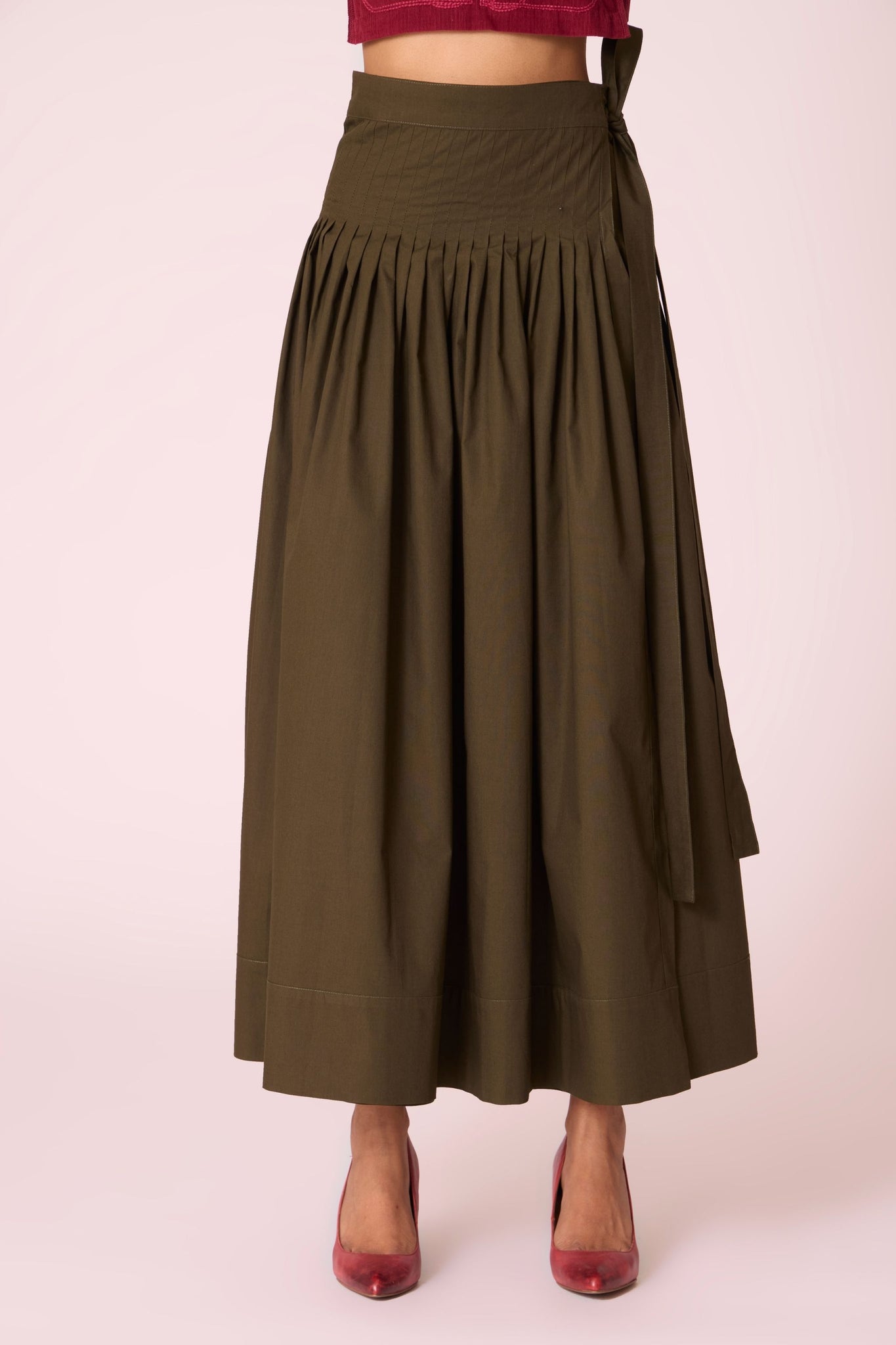 Green cotton poplin pleated midi wrap skirt with adjustable wrap fastening.