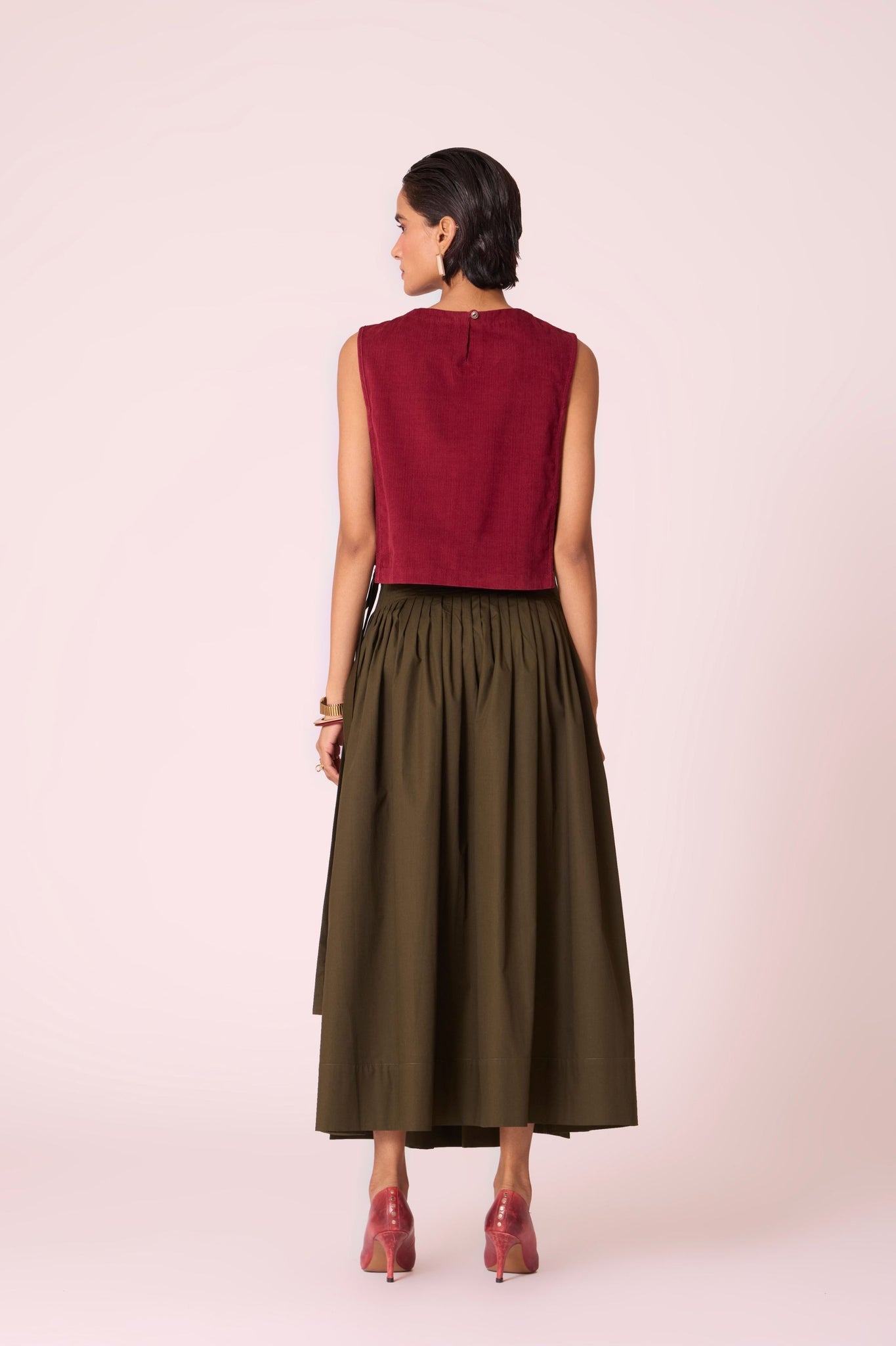 Green cotton poplin pleated midi wrap skirt with adjustable wrap fastening.