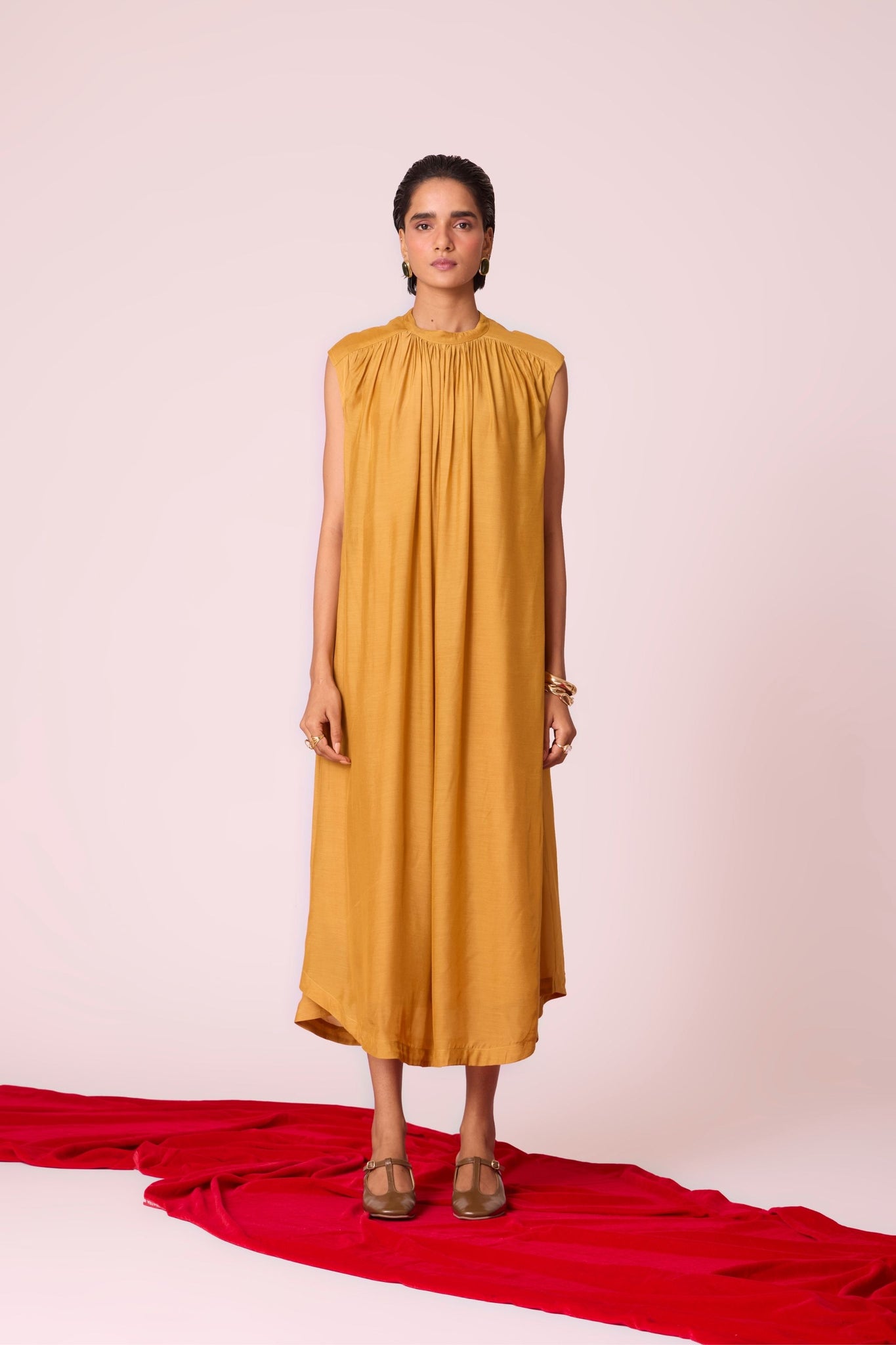 Yellow cupro midi dress with adjustable hand-embroidered belt, back button fastening, and slip included.
