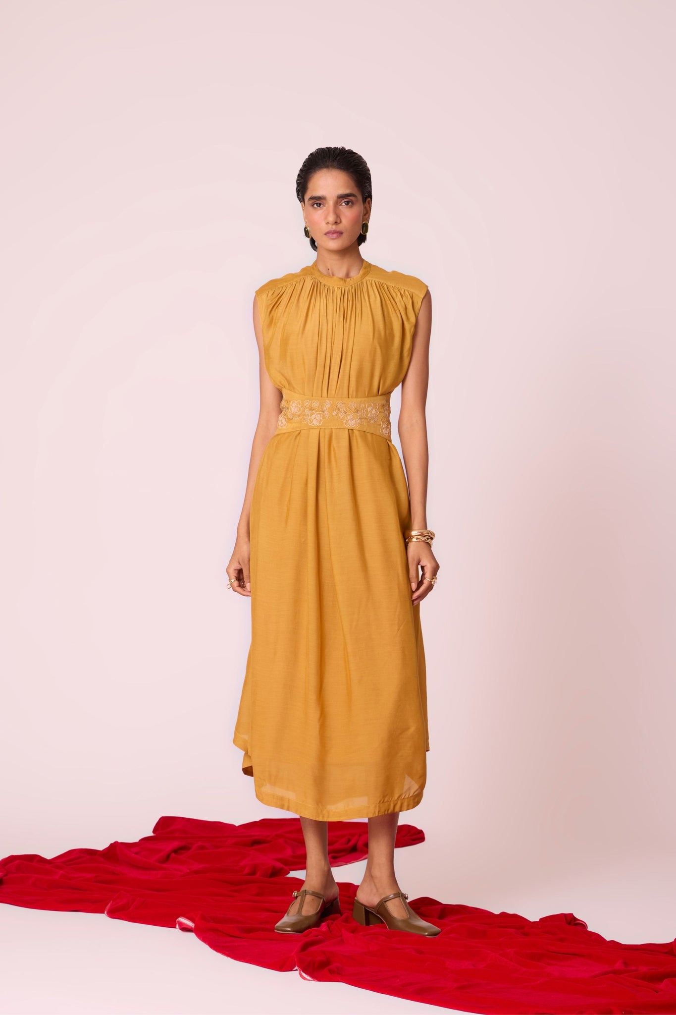 Yellow cupro midi dress with adjustable hand-embroidered belt, back button fastening, and slip included.

