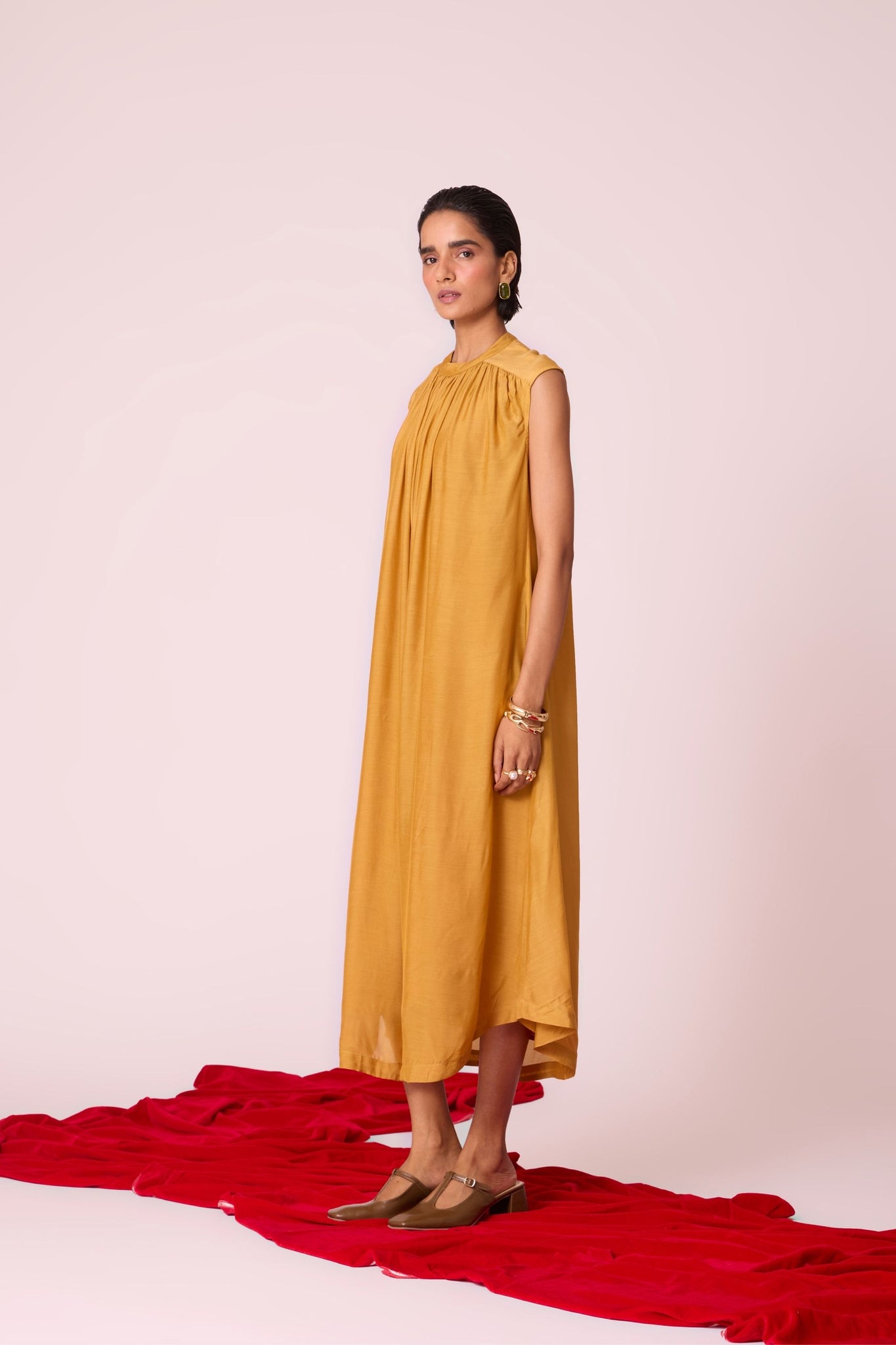 Yellow cupro midi dress with adjustable hand-embroidered belt, back button fastening, and slip included.
