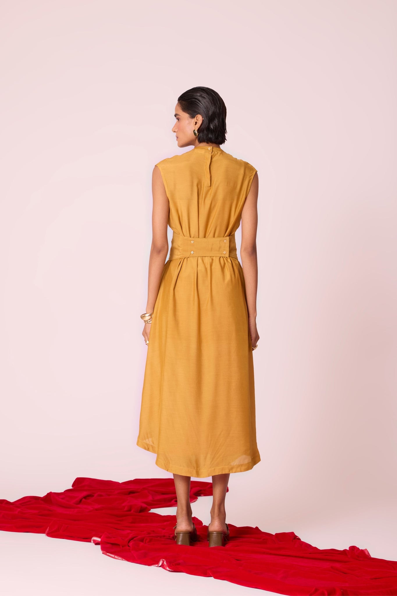 Yellow cupro midi dress with adjustable hand-embroidered belt, back button fastening, and slip included.
