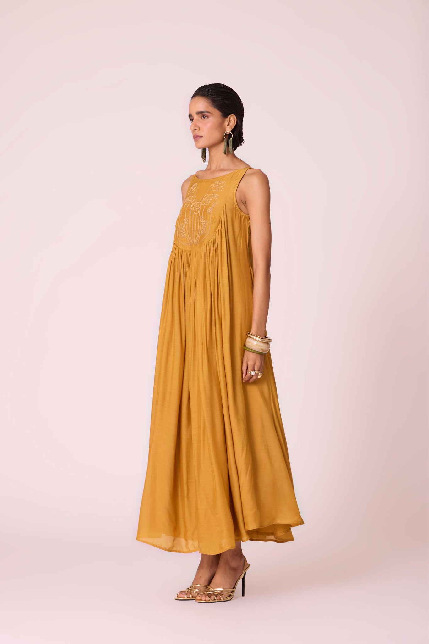 Yellow cupro maxi dress with hand-embroidered yoke, low scoop back with elastic strap, full lining, and light waist gathers.
