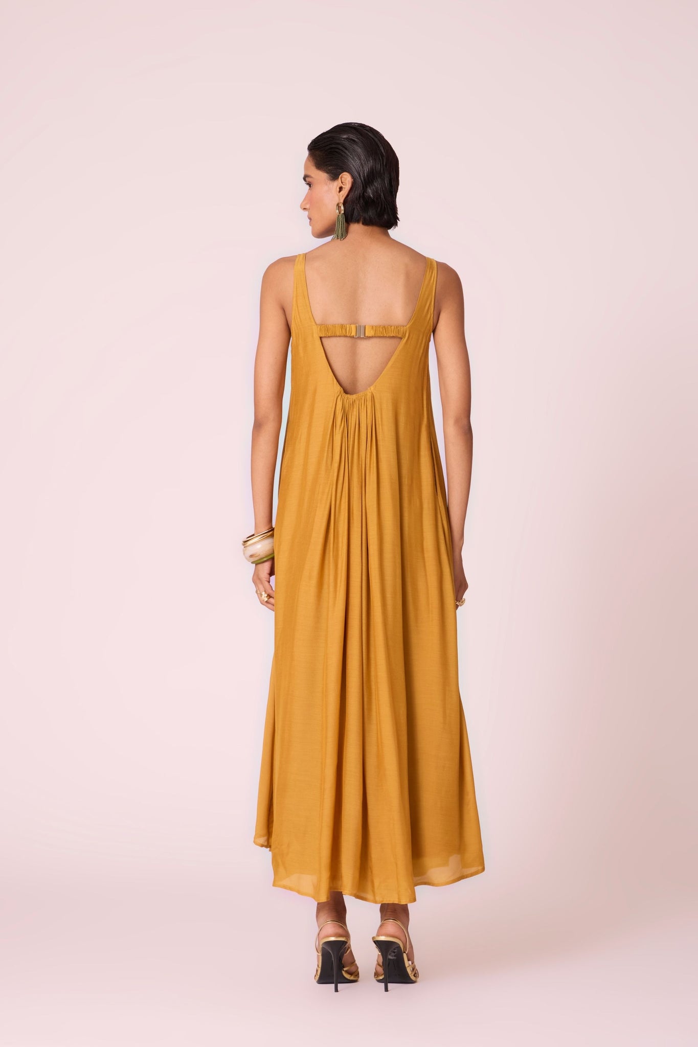Yellow cupro maxi dress with hand-embroidered yoke, low scoop back with elastic strap, full lining, and light waist gathers.
