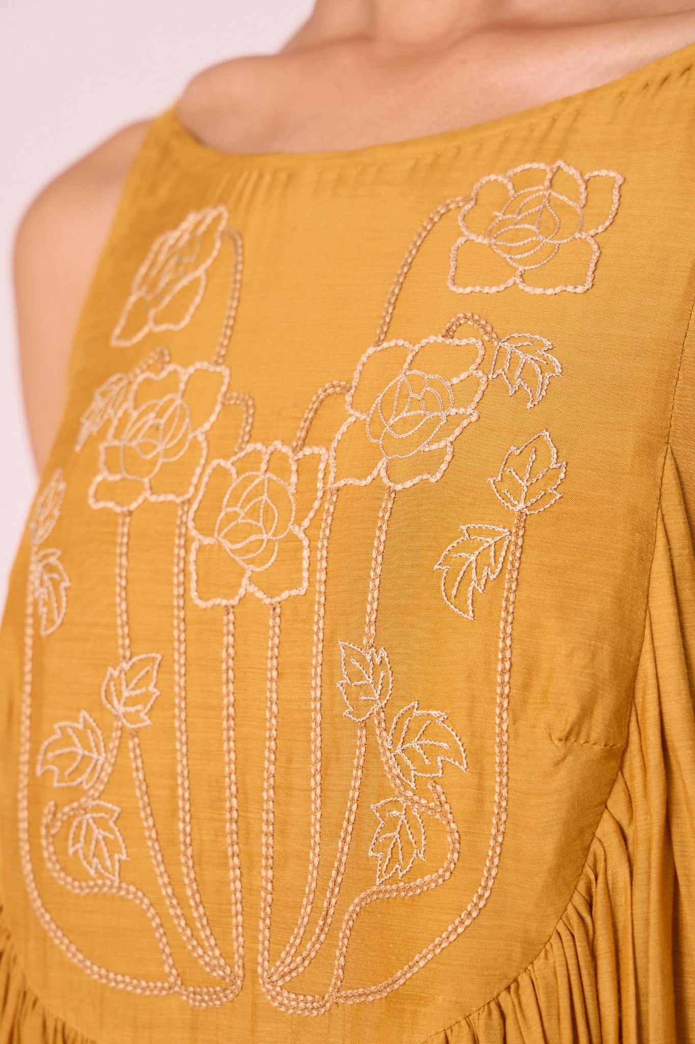 Yellow cupro maxi dress with hand-embroidered yoke, low scoop back with elastic strap, full lining, and light waist gathers.
