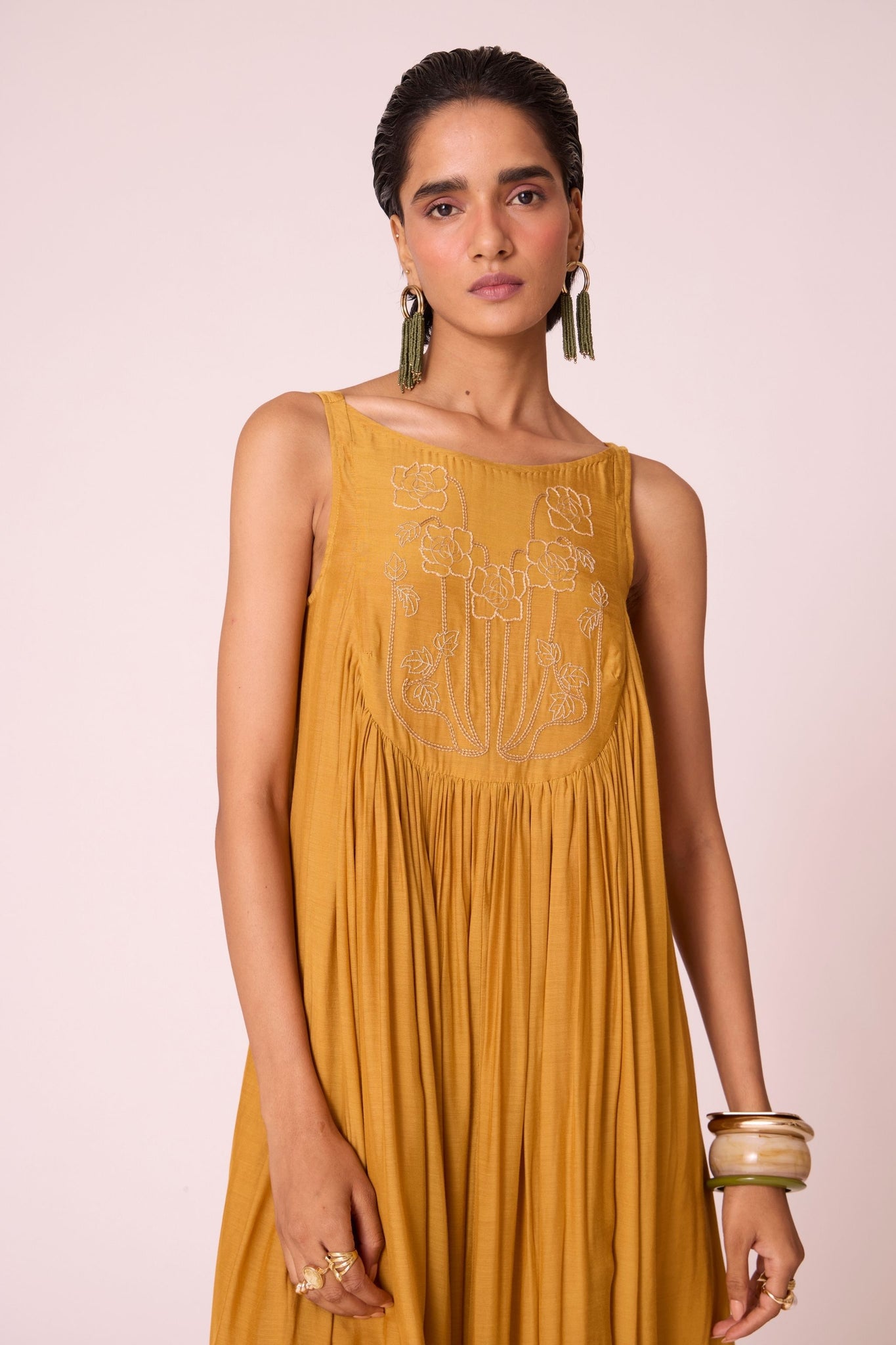 Yellow cupro maxi dress with hand-embroidered yoke, low scoop back with elastic strap, full lining, and light waist gathers.
