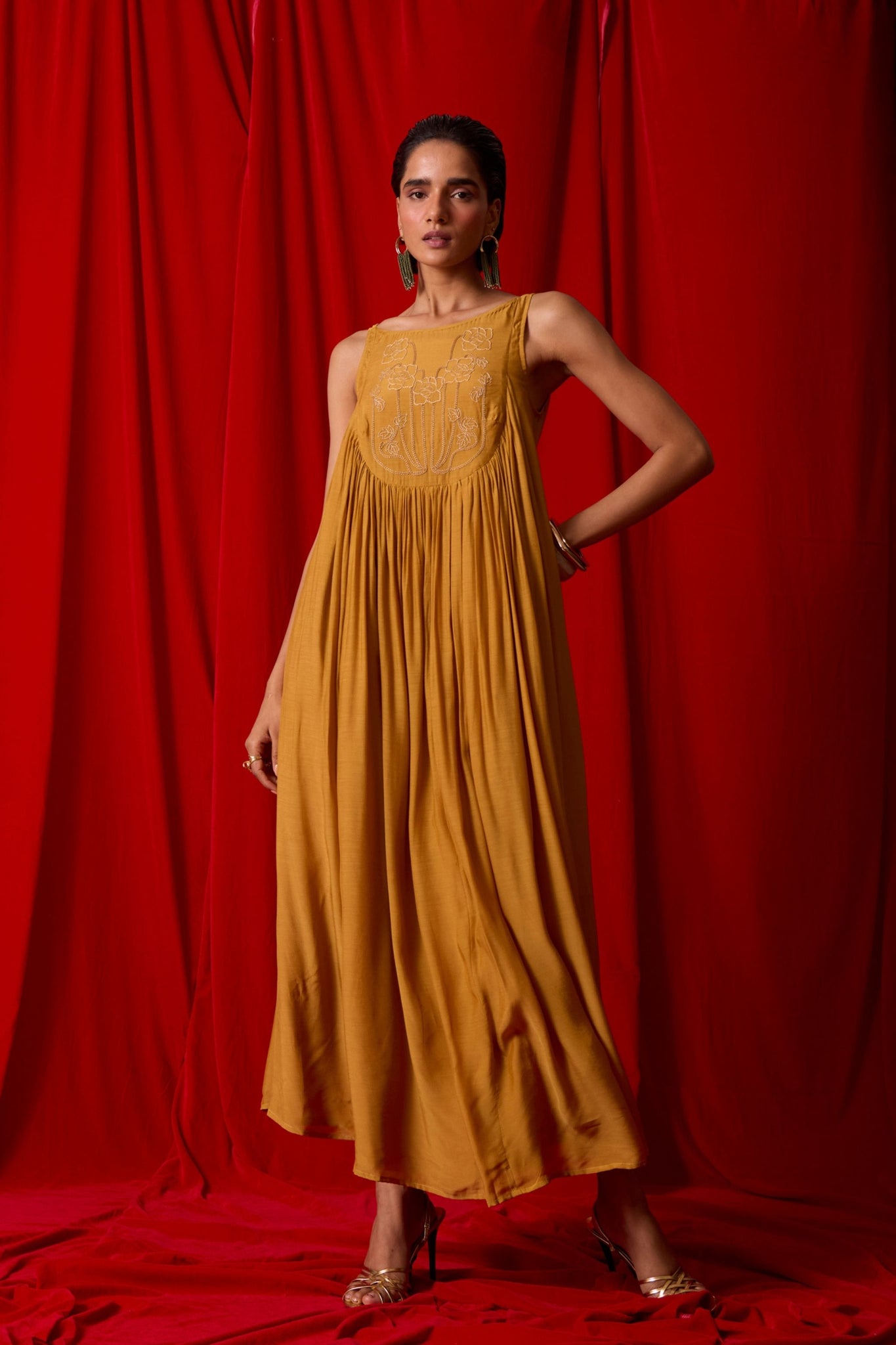 Yellow cupro maxi dress with hand-embroidered yoke, low scoop back with elastic strap, full lining, and light waist gathers.
