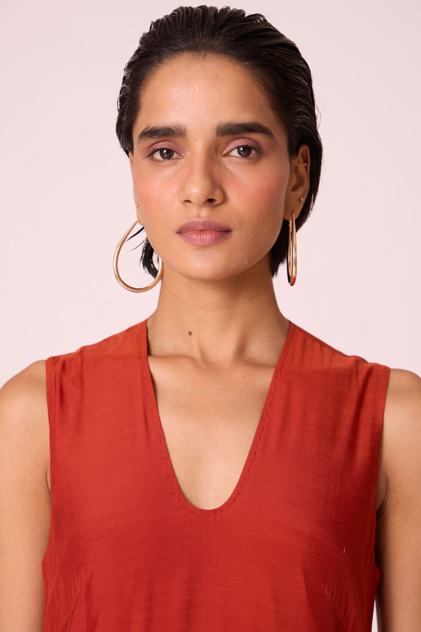 Rust cupro drop-waist dress with hand-embroidered waist, narrow scooped neckline, and full lining.
