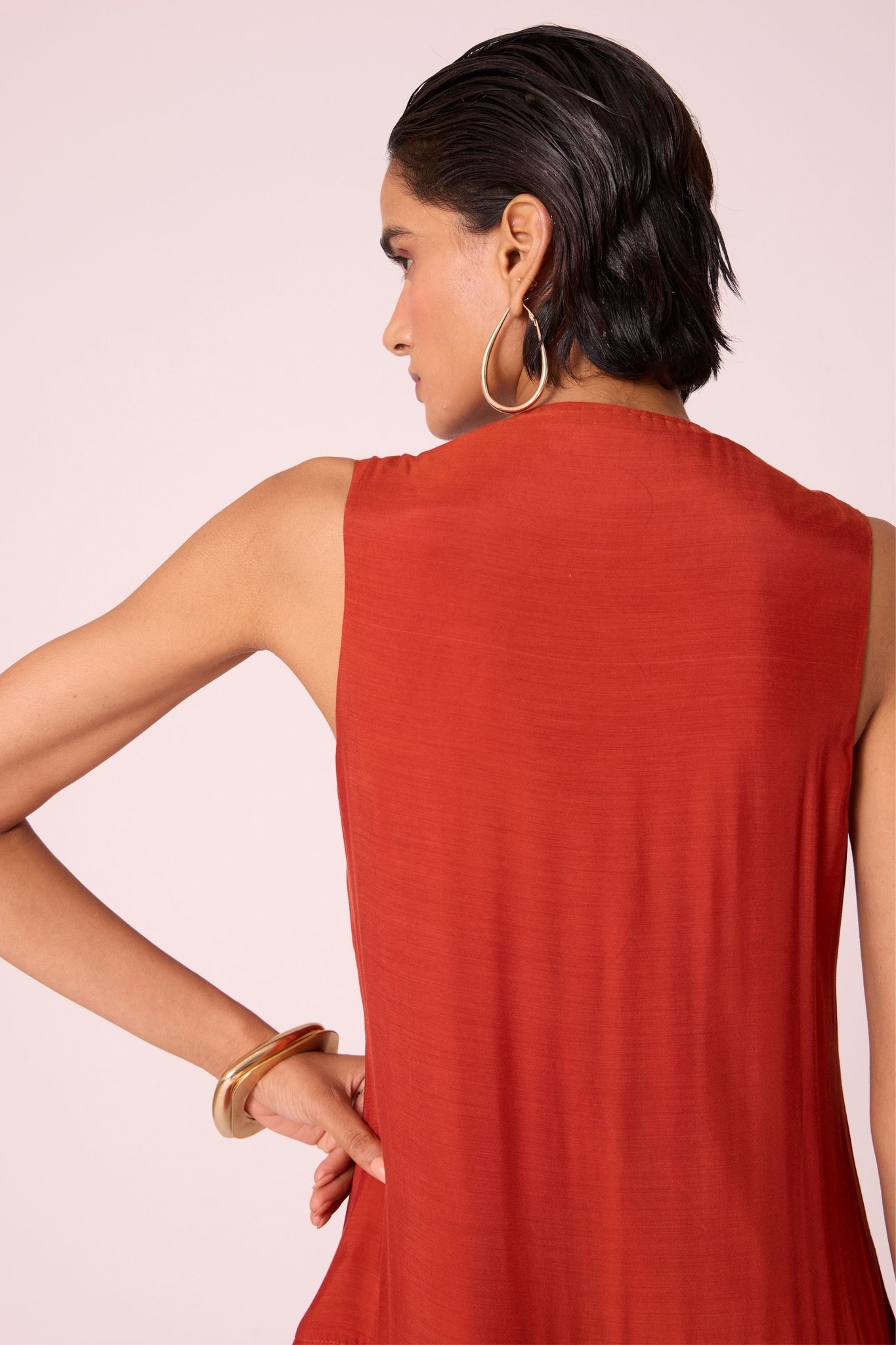 Rust cupro drop-waist dress with hand-embroidered waist, narrow scooped neckline, and full lining.
